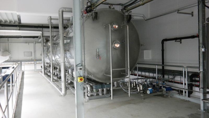 Im Vakuum-Bandtrockner wird das vorkonzentrierte Produkt auf einem Förderband durch eine Vakuumkammer geführt und durch verschiedene Heizzonen geleitet (Bild: Devex).