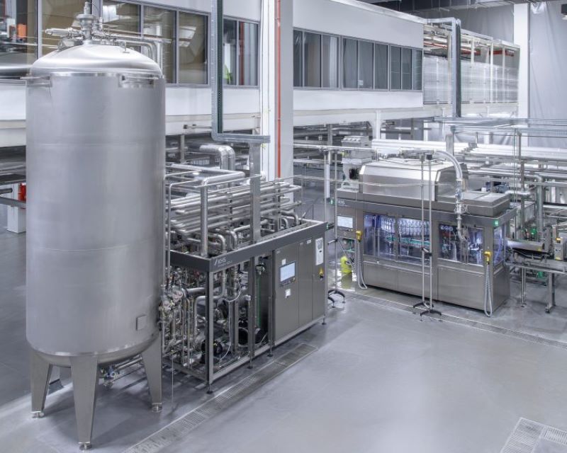 Im neuen Werk kommen moderne Prozess- und Fülltechnik zum Einsatz: links der Kurzzeiterhitzer, rechts der Dosenfüller (Bild: Frank Reinhold).