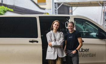 V. l.: Maja Ruhbach (Uber) undTheresa Breuer (Weingut Georg Breuer) vor einem »Weintaxi« von Taxi Frankfurt eG (Bild: Uber).
